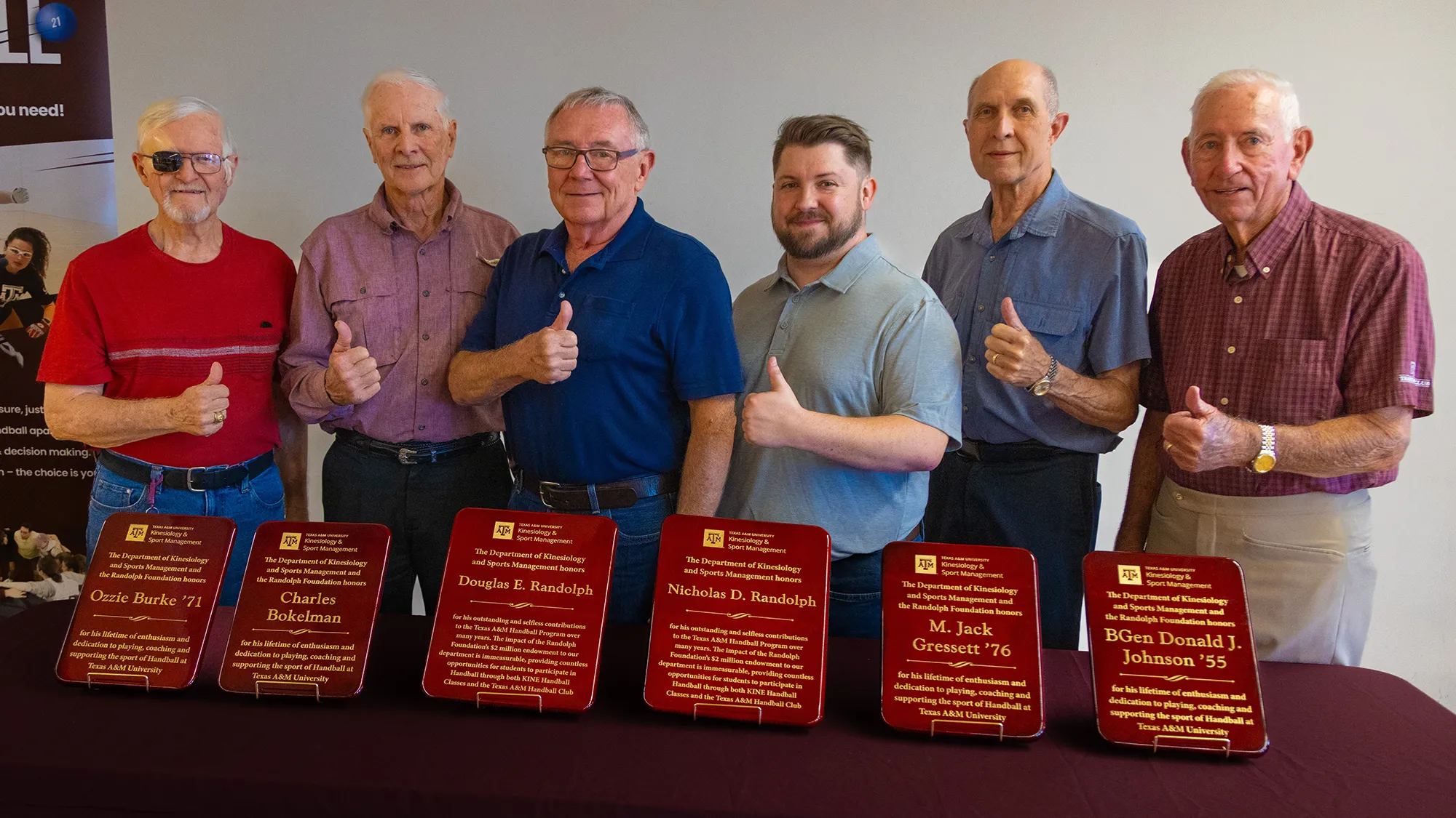 Several men stand with plaques.